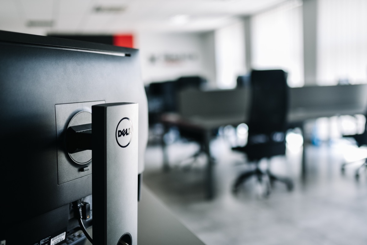 Monitor na stanowisku pracy w biurze BlackIce Networks, w tle sala ze stanowiskami